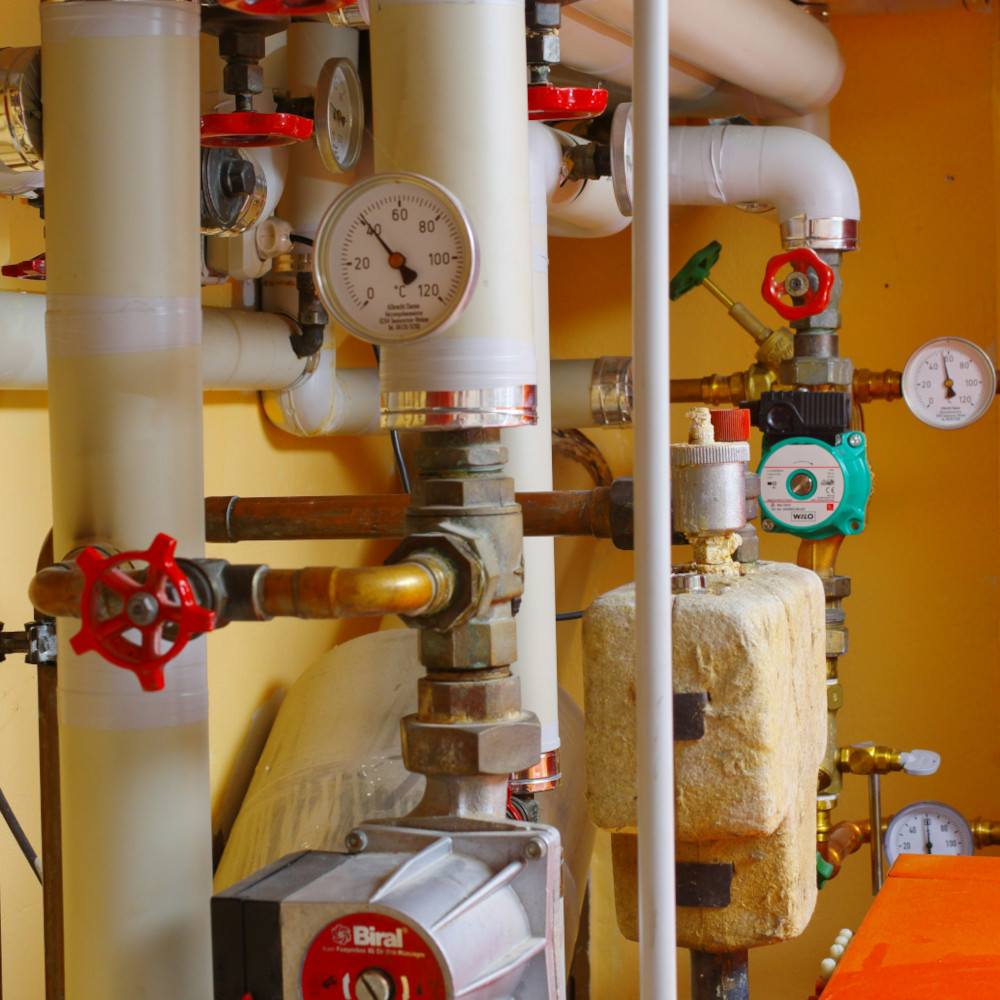 Sauber installierte Rohre und Pumpen für die Heizungsanlage eines Hauses.